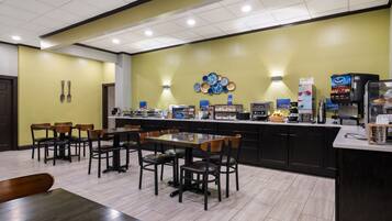 A restaurant with a counter, seating area, and various food service equipment.