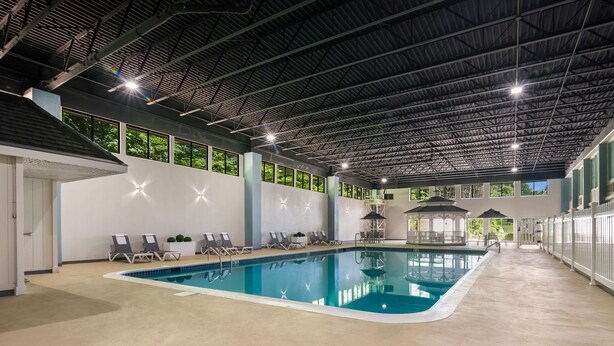 Une piscine intérieure avec des chaises longues et un kiosque.