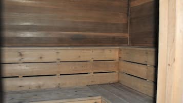 Una sauna de madera con bancos y suelo inclinado.