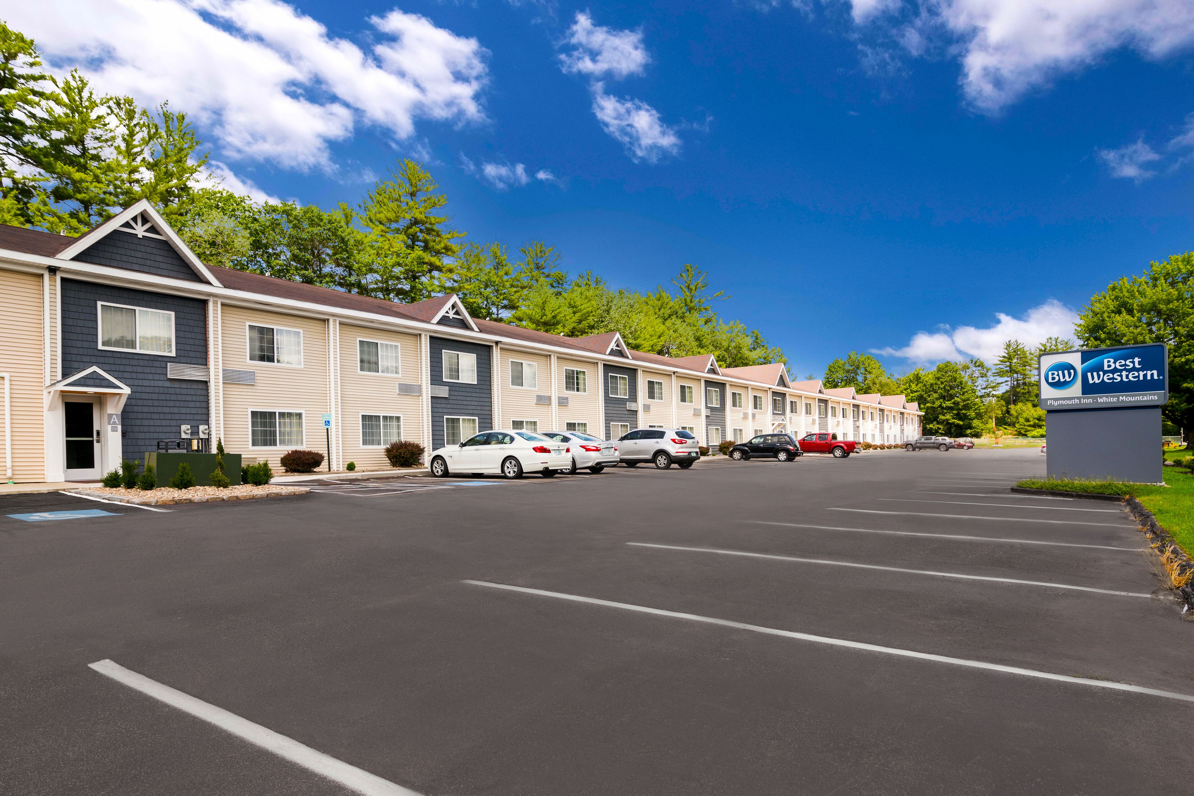 Un hôtel Best Western composé de plusieurs bâtiments à étages, avec un parking et plusieurs voitures garées devant.