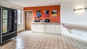 Una kitchenette equipada con microondas, cafetera y máquina expendedora.