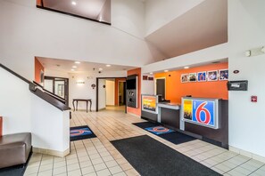 A hotel lobby with a reception desk, a staircase, and a tiled floor. - Motel 6 Harvey, IL (Harvey)