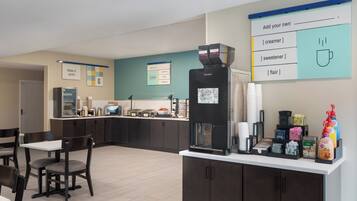Een modern café met een koffieapparaat, een zithoek en een menubord.