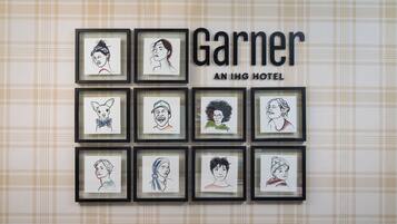 A wall with framed portraits and the text "Garner AN IHG HOTEL".