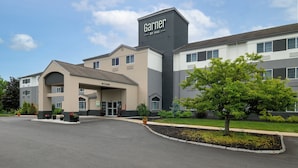 A hotel with a modern design, featuring a prominent entrance, a parking lot, and landscaped areas with trees and shrubs. - Garner Hotel Londonderry - Manchester by IHG (Londonderry)