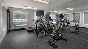 A gym with stationary bikes, elliptical machines, and a mirrored wall. - Garner Hotel Londonderry - Manchester by IHG (Londonderry)