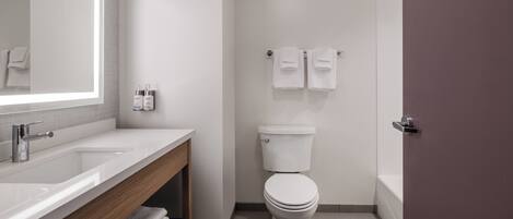 A modern bathroom with a white sink, a toilet, and a shower area.