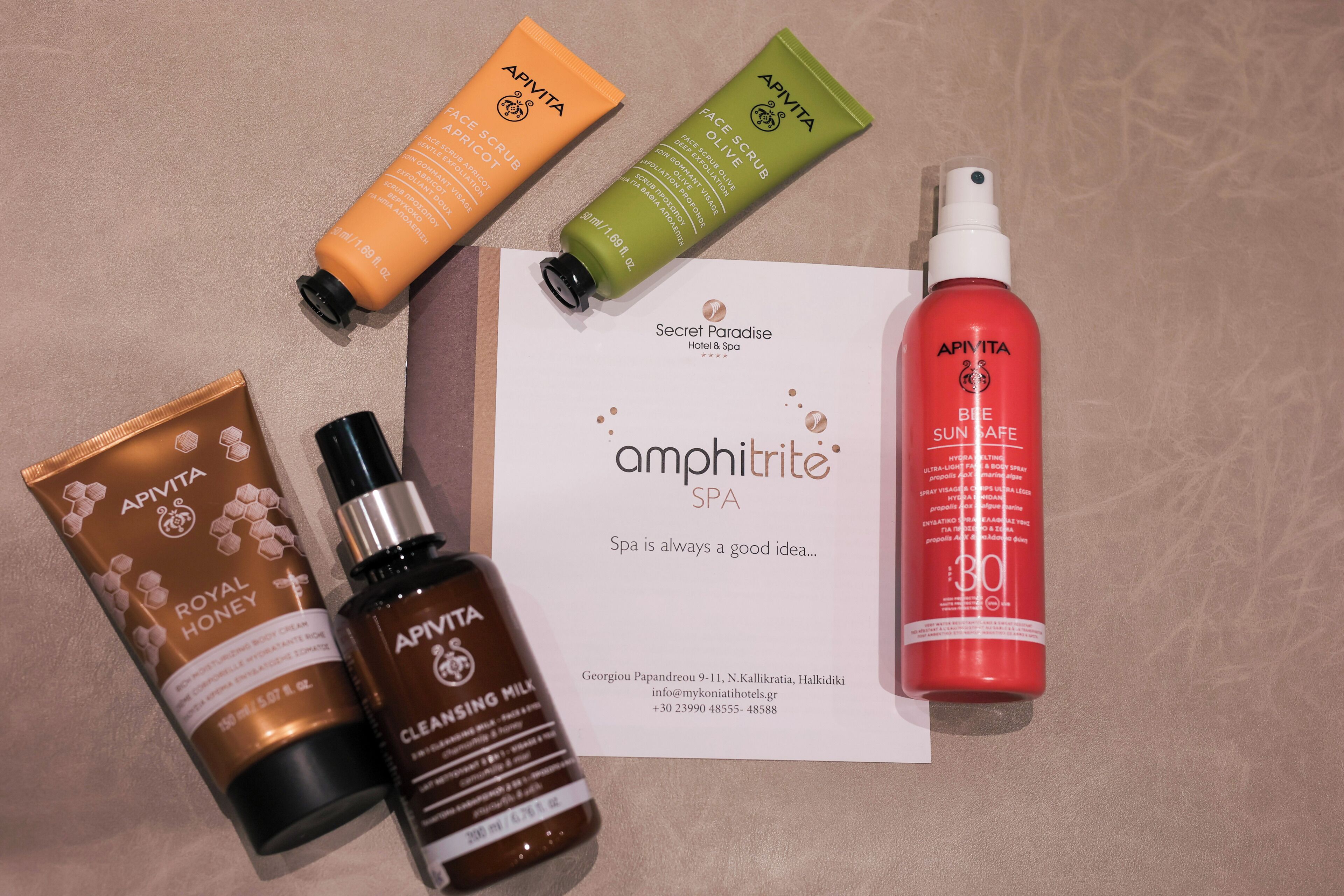 Various skincare products arranged on a surface with a spa brochure.
