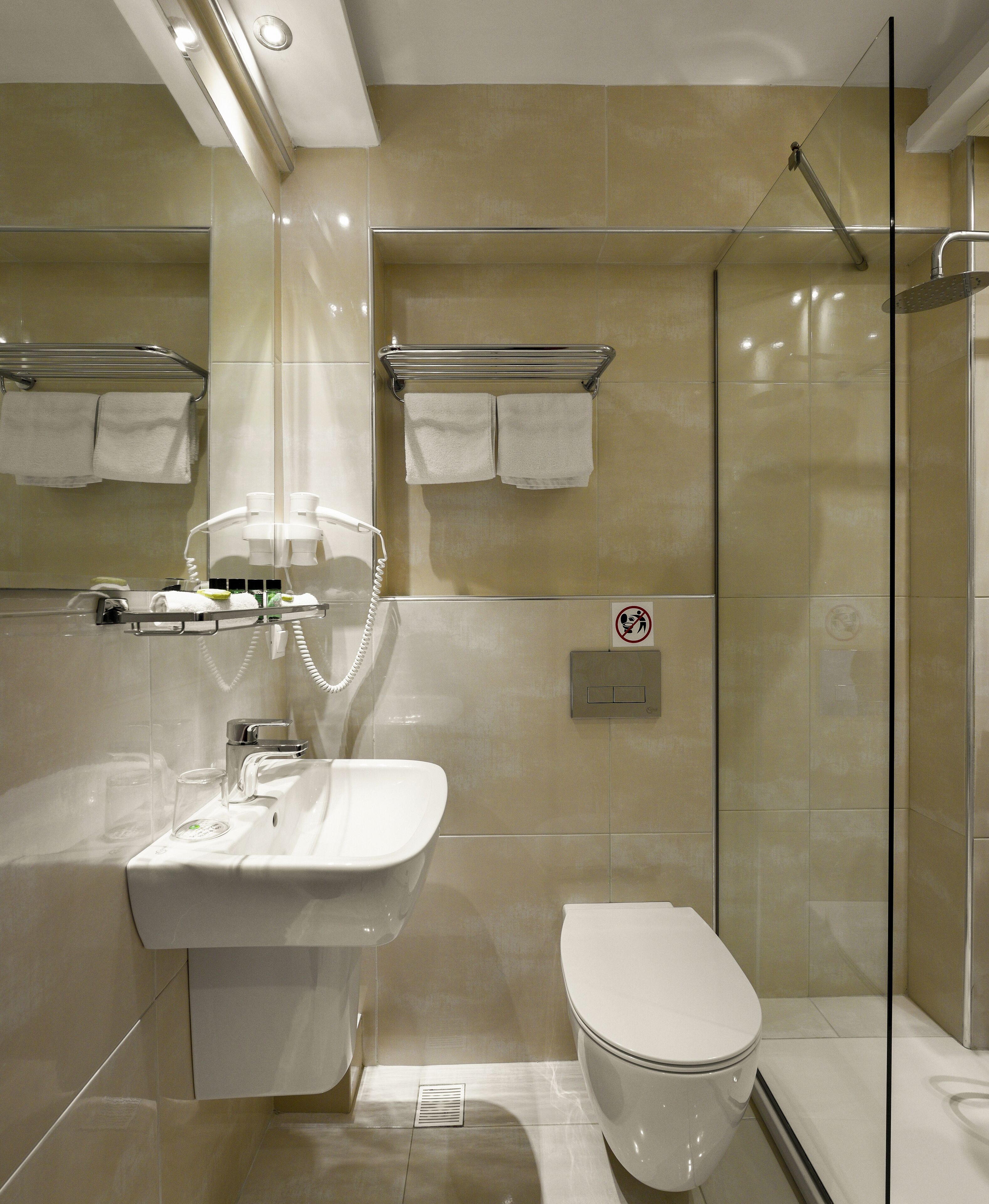 A modern bathroom with a sink, toilet, and glass-enclosed shower.