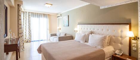 A hotel room with a large bed, bedside tables, a desk, and a chair.