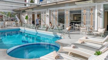 Una piscina cubierta, una piscina al aire libre, tumbonas