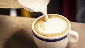 A cup of coffee with milk being poured into it. - Hotel Villa Edera (Venice)