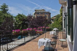 A terrace with outdoor seating, a view of a historic building, and a clear sky. - Hotel Villa Edera (Venice)