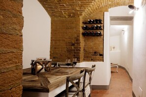 A rustic dining area with a brick wall, wooden table, and chairs. - Hotel La Gioconda (Florence)