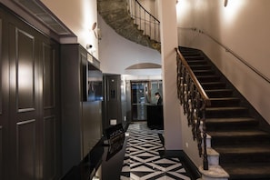 A hotel lobby with a black and white patterned floor, a staircase with ornate balustrades, and a reception desk. - Hotel La Gioconda (Florence)