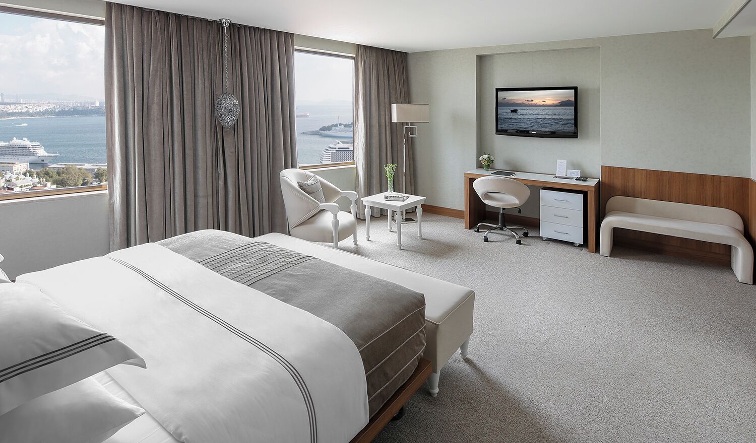 Une chambre d’hôtel équipée d’un lit, d’un bureau, d’une chaise et d’un téléviseur.