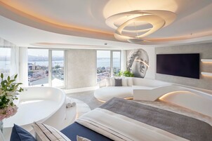 A modern living room with a large window, a bathtub, and a flat-screen TV.
