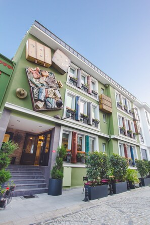 Un edificio con varios balcones, ventanas amplias y plantas en macetas.