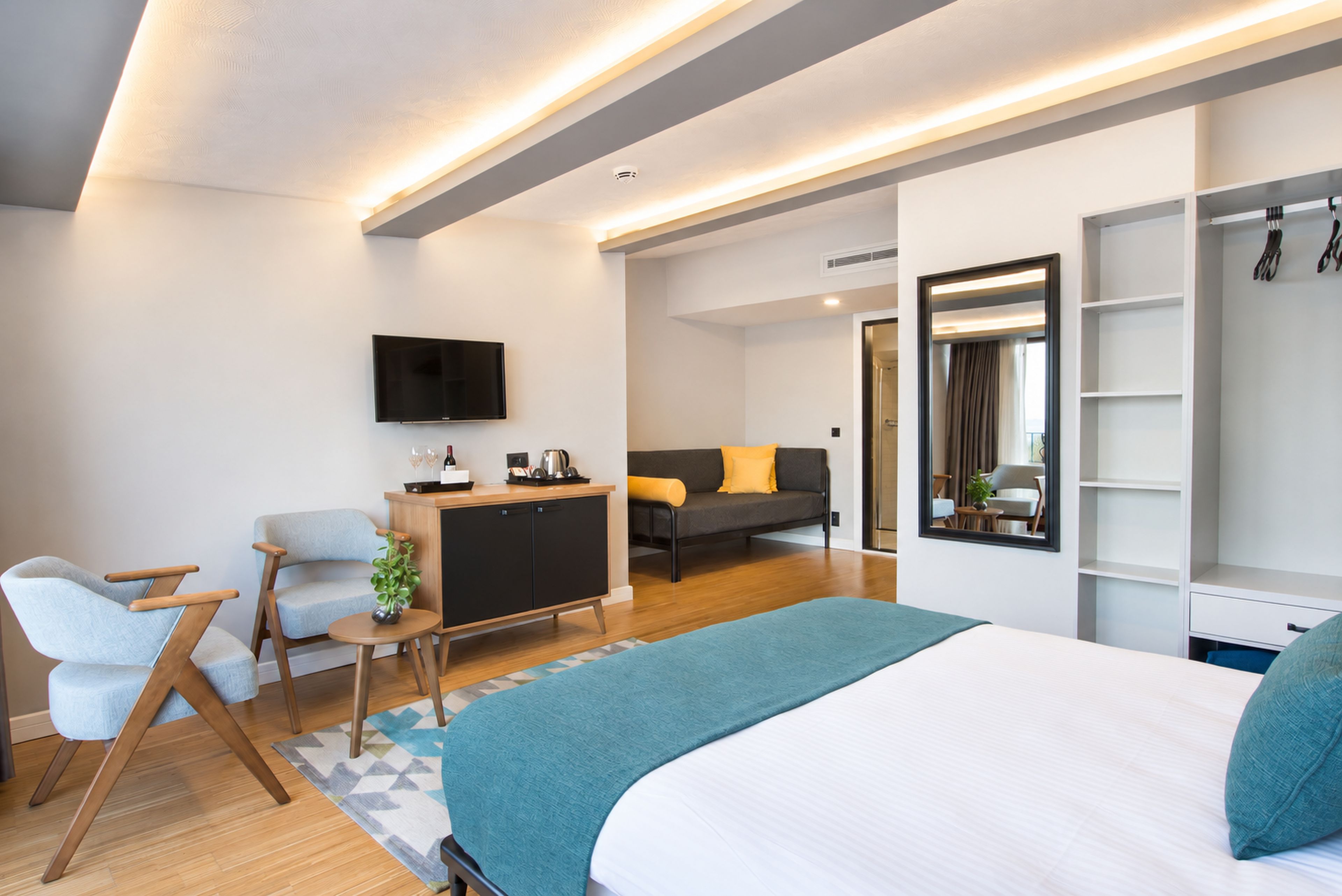 Une chambre d’hôtel moderne équipée d’un lit, d’un bureau, d’un canapé et d’une télévision.