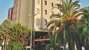 Un hôtel à plusieurs étages, doté d’une façade beige, de nombreuses fenêtres et de balcons.
