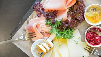 Una tabla de embutidos con carnes frías, queso y diferentes acompañamientos.