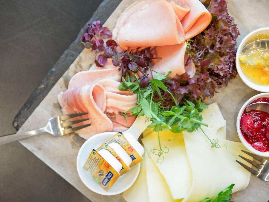 Una tabla de embutidos con carnes frías, queso y diferentes acompañamientos.