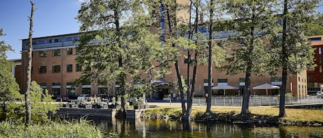 Vista de un edificio a la orilla del río, con terraza al aire libre y fachada de ladrillo.