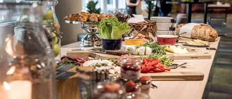 A buffet with various food items including meats, cheeses, and vegetables.