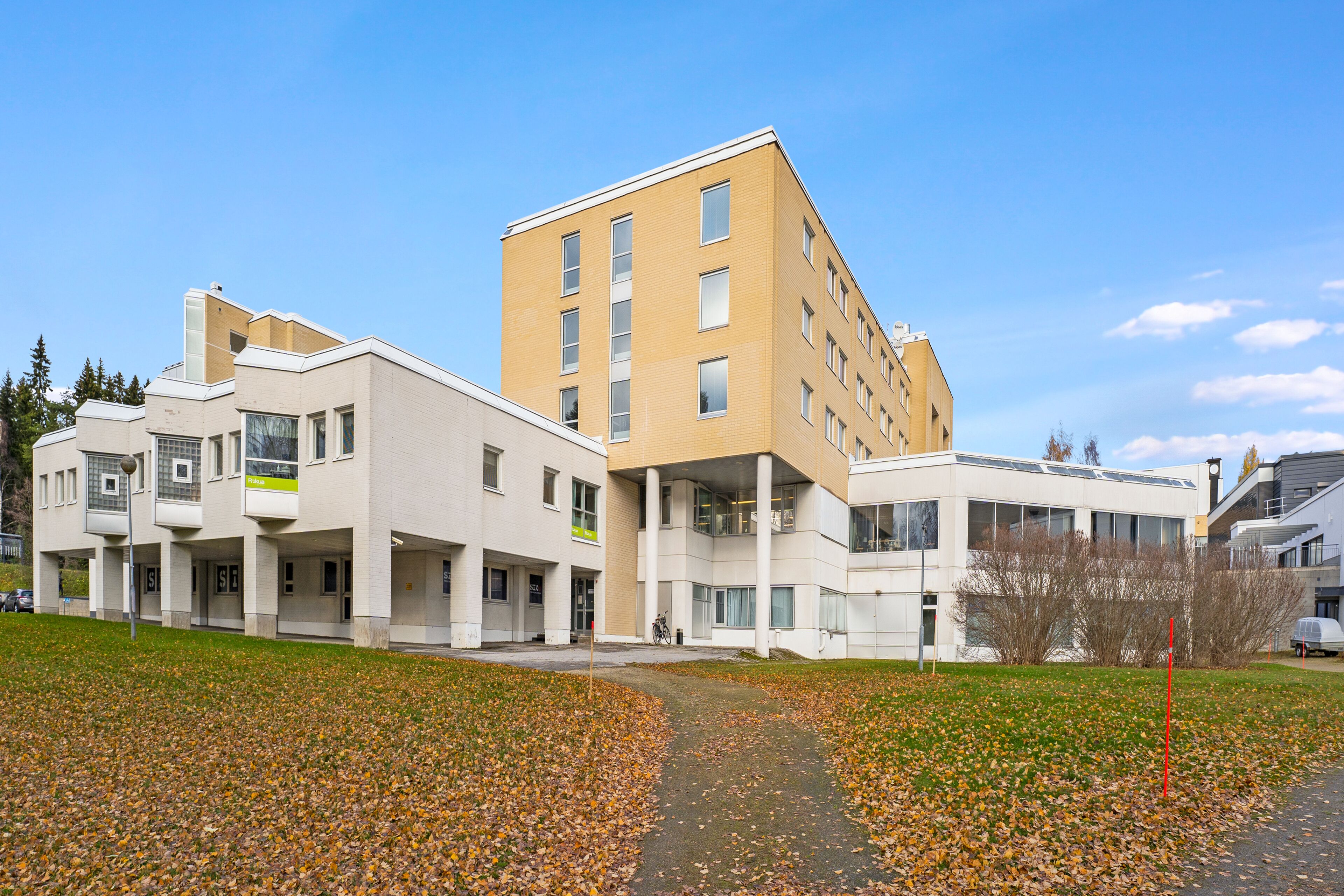 Un edificio moderno con varios pisos, ventanas amplias y techo plano.