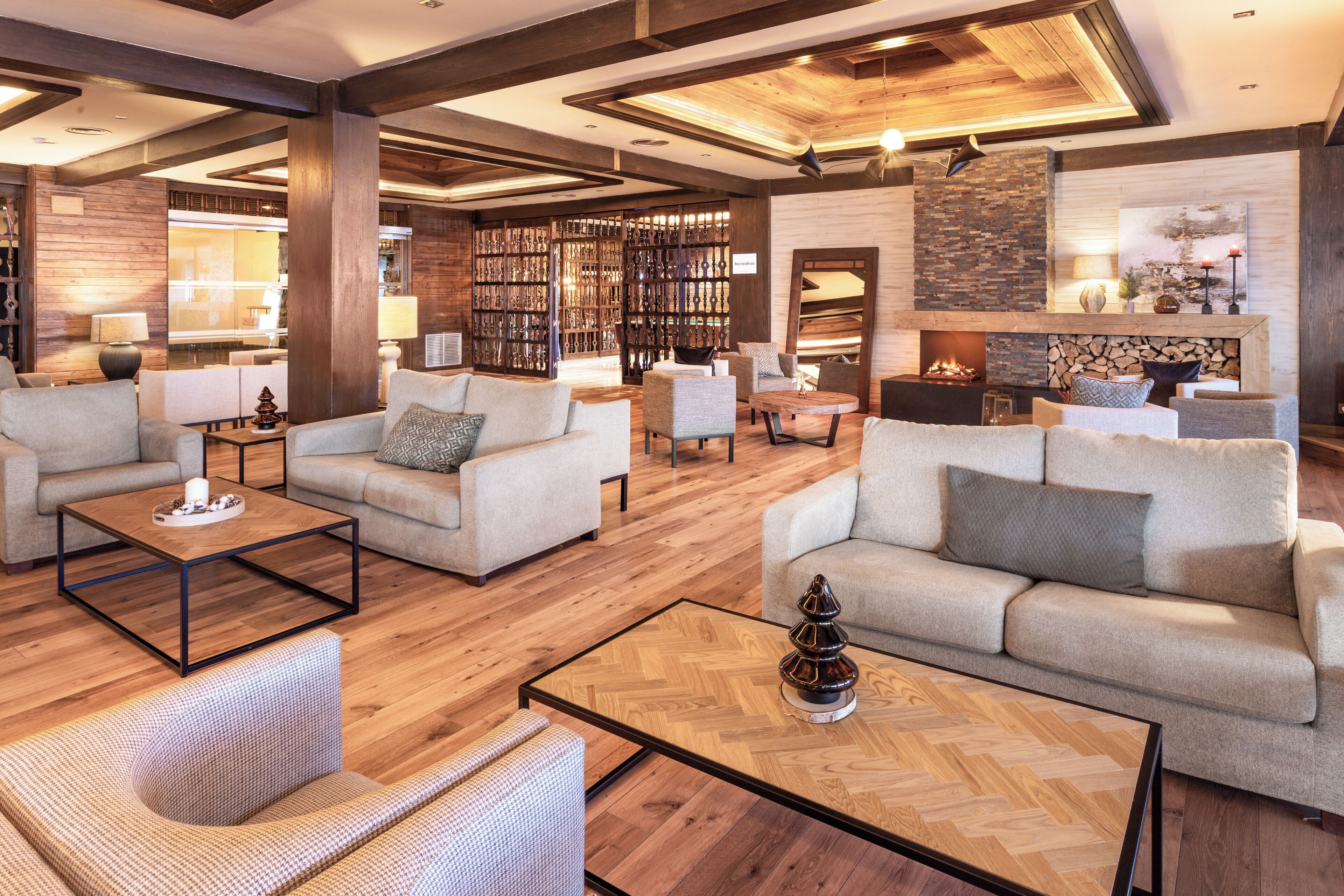 A spacious lobby with multiple seating areas, a fireplace, and a large bookshelf.