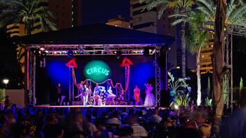 Un escenario de circo con artistas y un público.