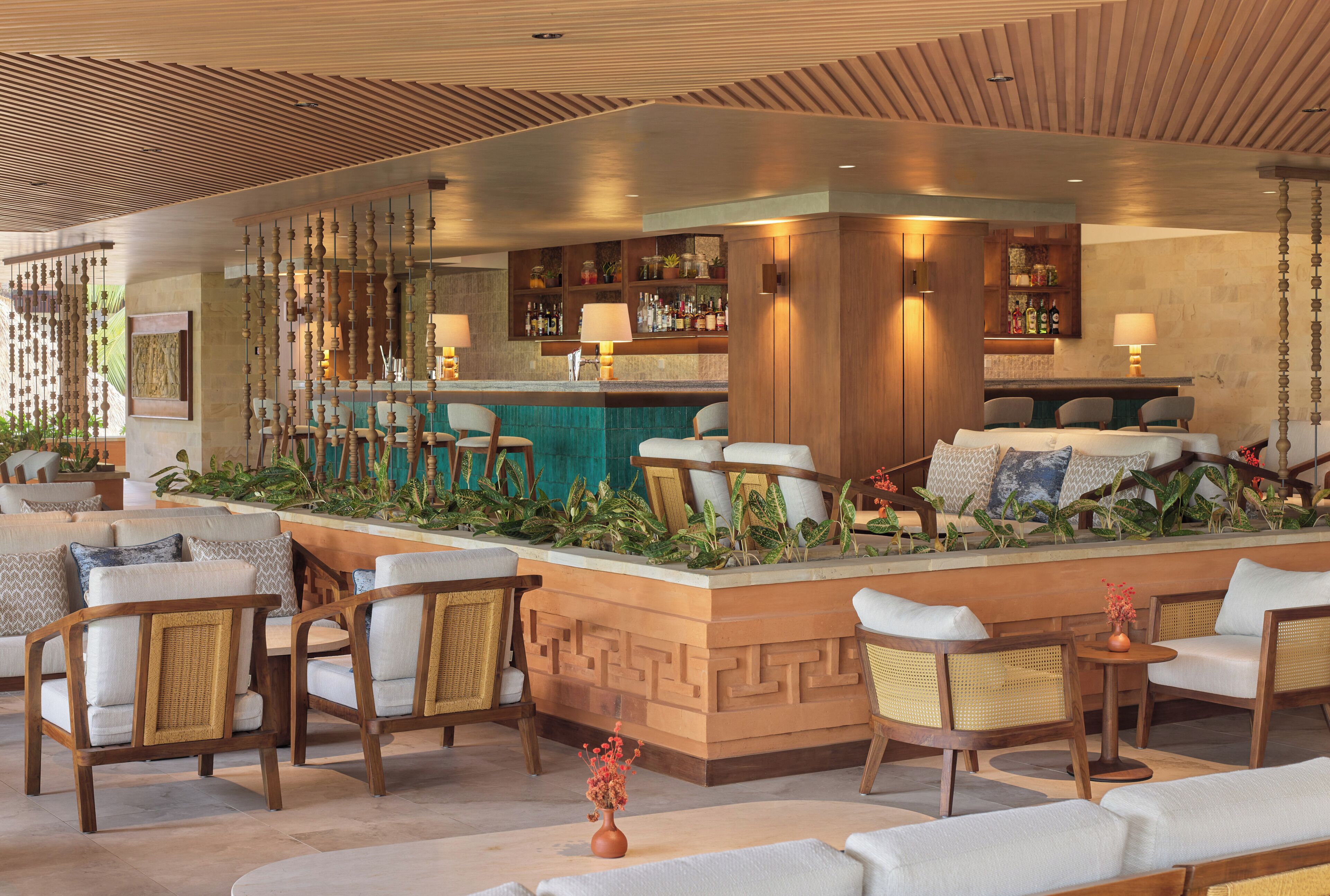A bar area with seating, a bar counter, and a decorative plant arrangement.
