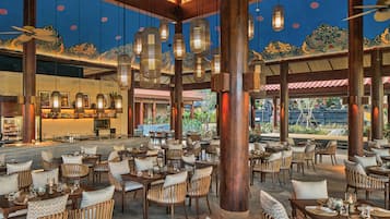 Un restaurante espacioso con techos altos, faroles colgantes y decoración tradicional.