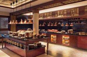 A well-lit kitchen with copper pendant lights, a central island with dishes, and shelves with kitchenware. - Paradisus by Meliá Bali (Nusa Dua)
