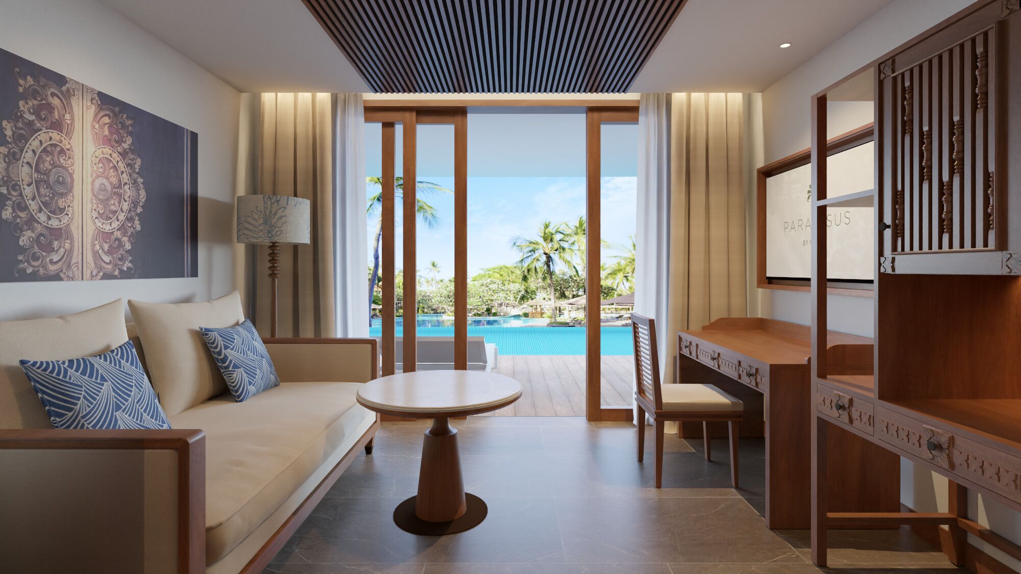 A modern hotel room with a sofa, a round table, a desk, and a view of a pool.