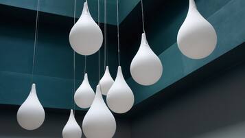 A ceiling with multiple white pendant lights hanging in a modern, geometric pattern.