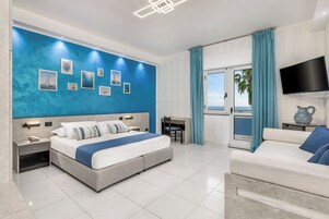 Quarto quádruplo júnior, vista para o mar | Frigobar, escrivaninha, espaço de trabalho para notebook