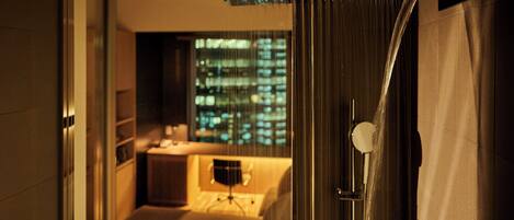 A hotel room with a view of a cityscape through a window.
