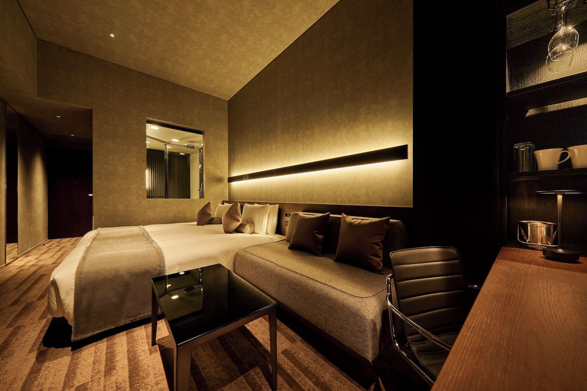Een moderne hotelkamer met een groot bed, een bank, een bijzettafeltje en een bureau.