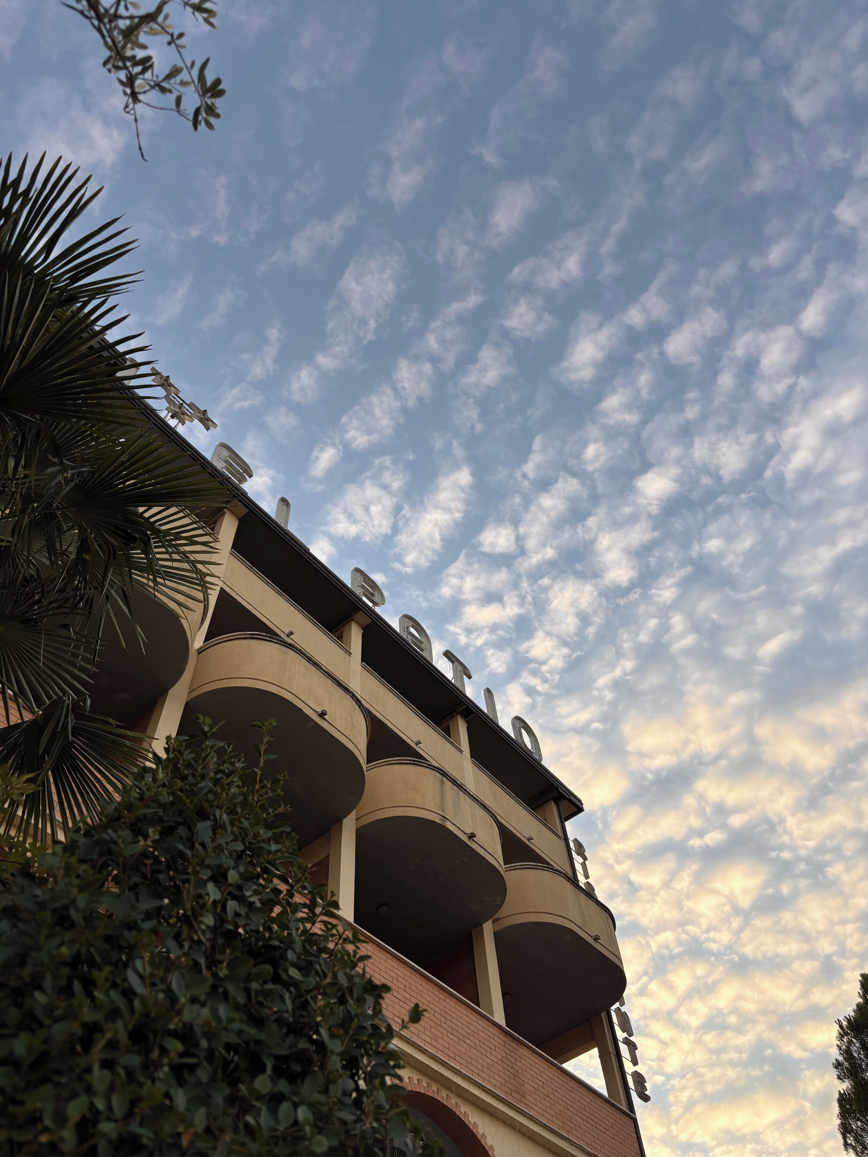A building with multiple balconies and a sign that reads "HOTEL".