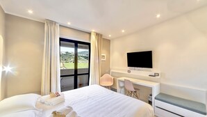 A hotel room with a bed, a desk, a chair, a TV, and a view of the outdoors. - Hotel El Patio (Corciano)
