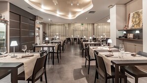 A modern restaurant with multiple tables, each set with wine glasses and napkins. - Hotel El Patio (Corciano)