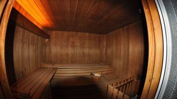 A sauna with wooden benches and a bench with a bucket.