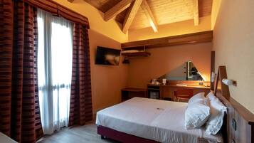 A hotel room with a bed, a desk, a chair, and a telephone.