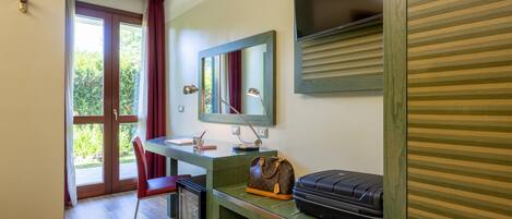 A room with a desk, chair, and a suitcase.