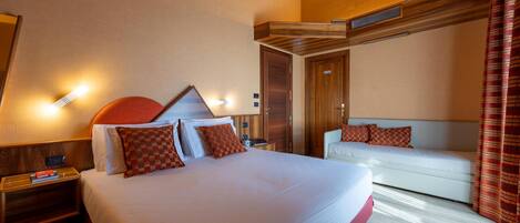 Una habitación de hotel con una cama grande, un sofá, un escritorio y un armario.