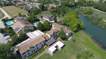 An aerial view of a residential area with houses, a swimming pool, and a river.