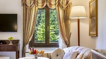 Una habitación acogedora con un sofá, una mesa con lámpara y una ventana con cortinas.