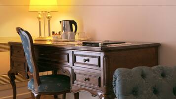 Un bureau en bois, une lampe, une cafetière et une chaise avec un coussin.
