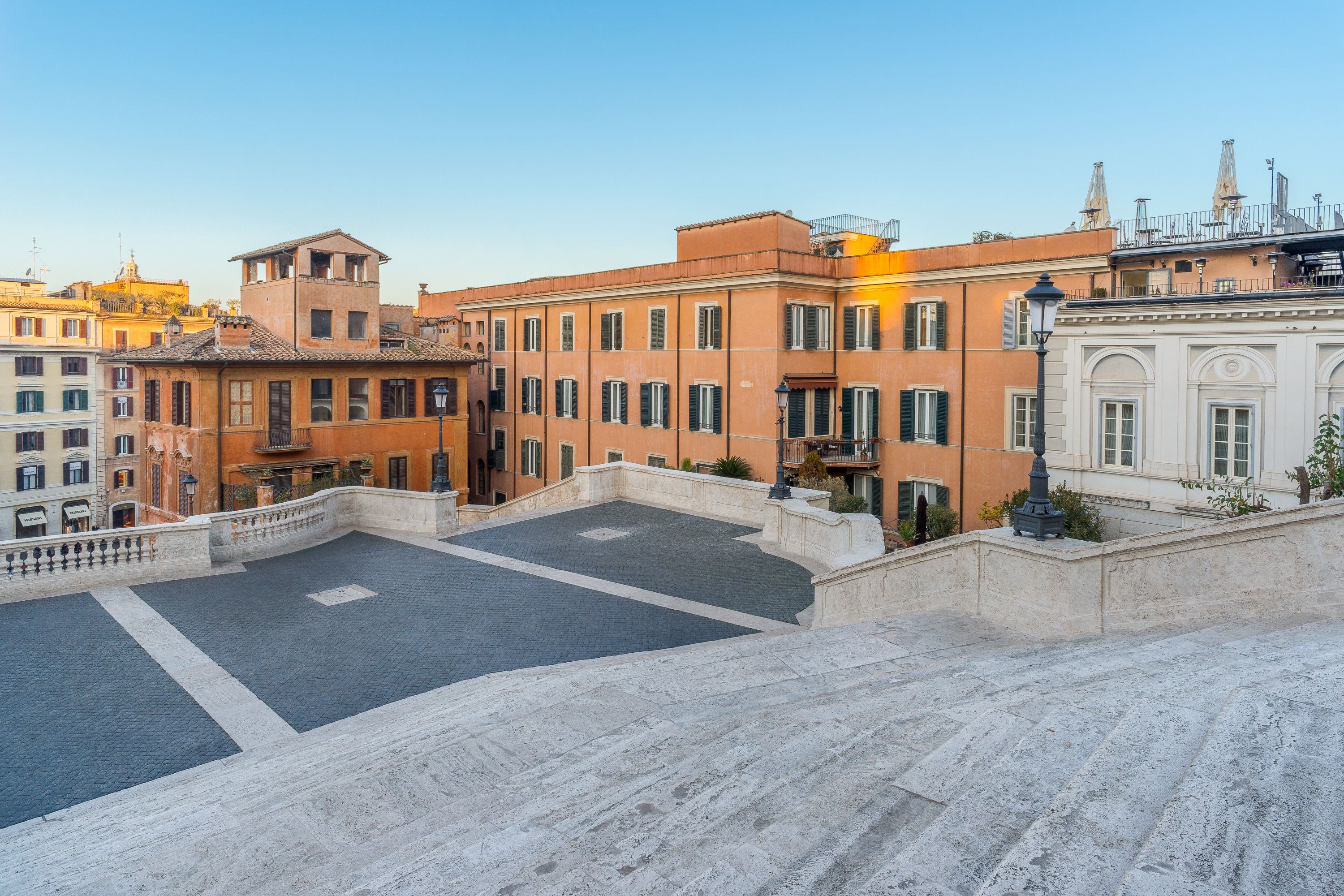 A courtyard with a paved area surrounded by buildings with balconies and windows.